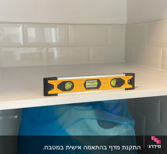 פלס על מדף במטבח עם אריחים לבנים